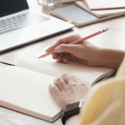 ノートにメモを取りながら学んでいる様子の写真